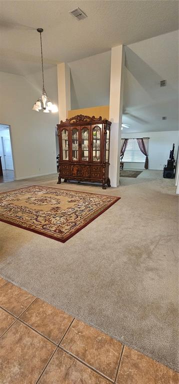 A dining area with a large wooden hutch, a patterned rug, and vaulted ceilings — 23705 MILFORD DRIVE, EUSTIS, FL