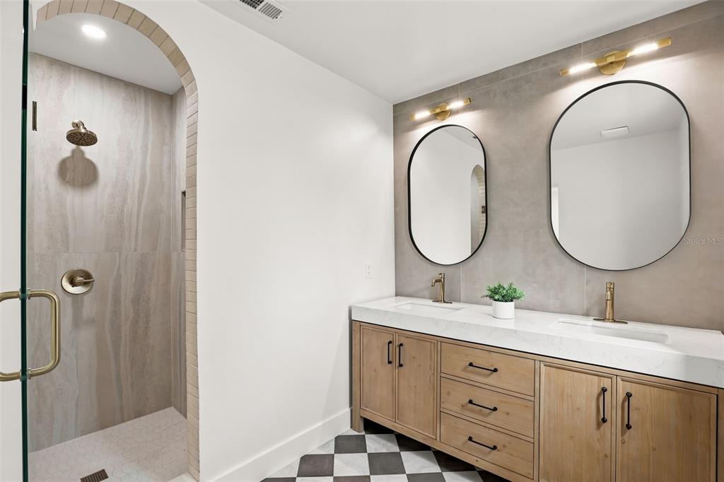 A bathroom features a double vanity, arched shower entrance, and black-and-white checkered floor tiles — 900 CARVER STREET, WINTER PARK, FL