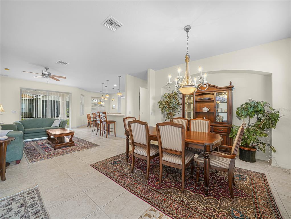 A dining room with a wooden table and hutch sits adjacent to a living area — 5264 GREEN DRIVE, WINTER HAVEN, FL