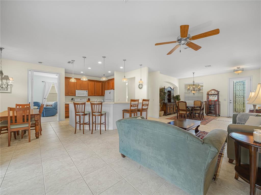 An open-concept living area features a kitchen with bar seating, a dining space, and tile flooring — 5264 GREEN DRIVE, WINTER HAVEN, FL