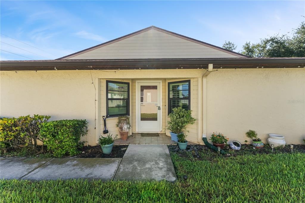 The exterior of a single-story home features a beige stucco facade and a recessed front entrance — 3312 60TH AVENUE W, BRADENTON, FL