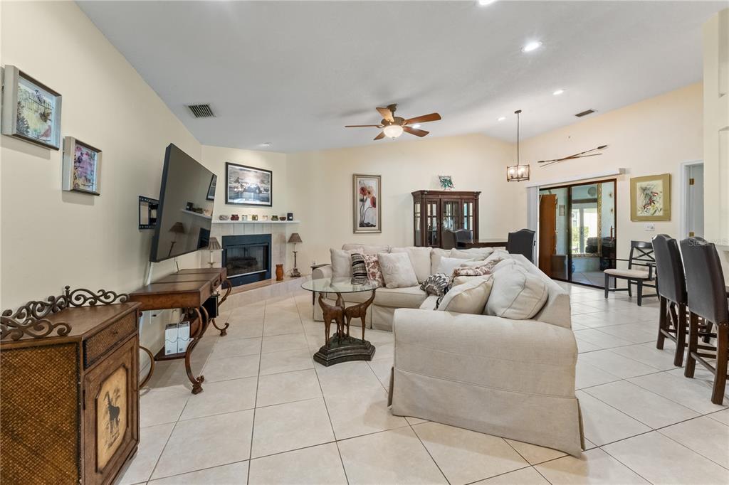 A living room features a fireplace, a large sectional sofa, and tile flooring — 3312 60TH AVENUE W, BRADENTON, FL