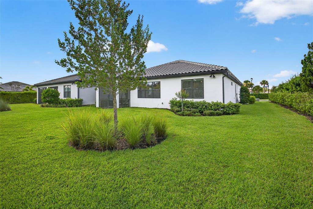 A modern living room features a sectional sofa, two armchairs, a coffee table, and a television — 12307 WIGEON DRIVE, BRADENTON, FL