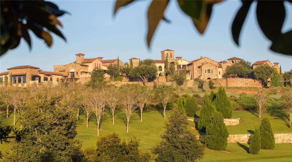 A large stone estate sits on a grassy hill surrounded by trees and landscaping — 16401 PENDIO DRIVE, MONTVERDE, FL
