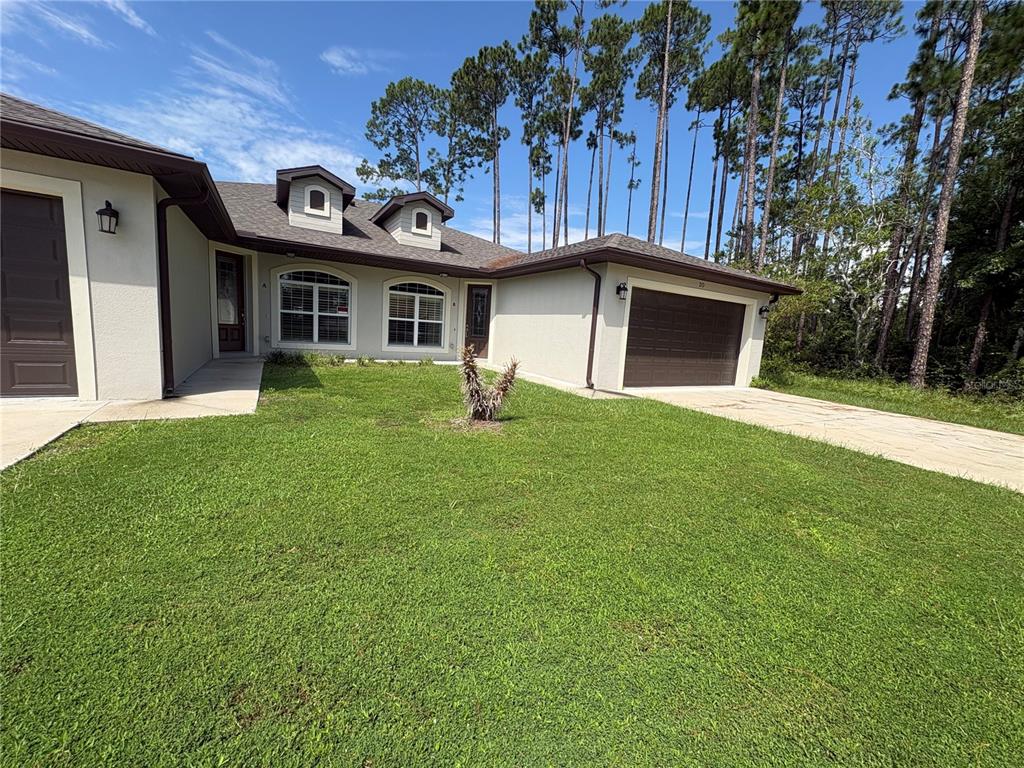 A concrete walkway leads to a brown front door with a glass insert and a window — 20 ETON LANE UNIT A & B, PALM COAST, FL