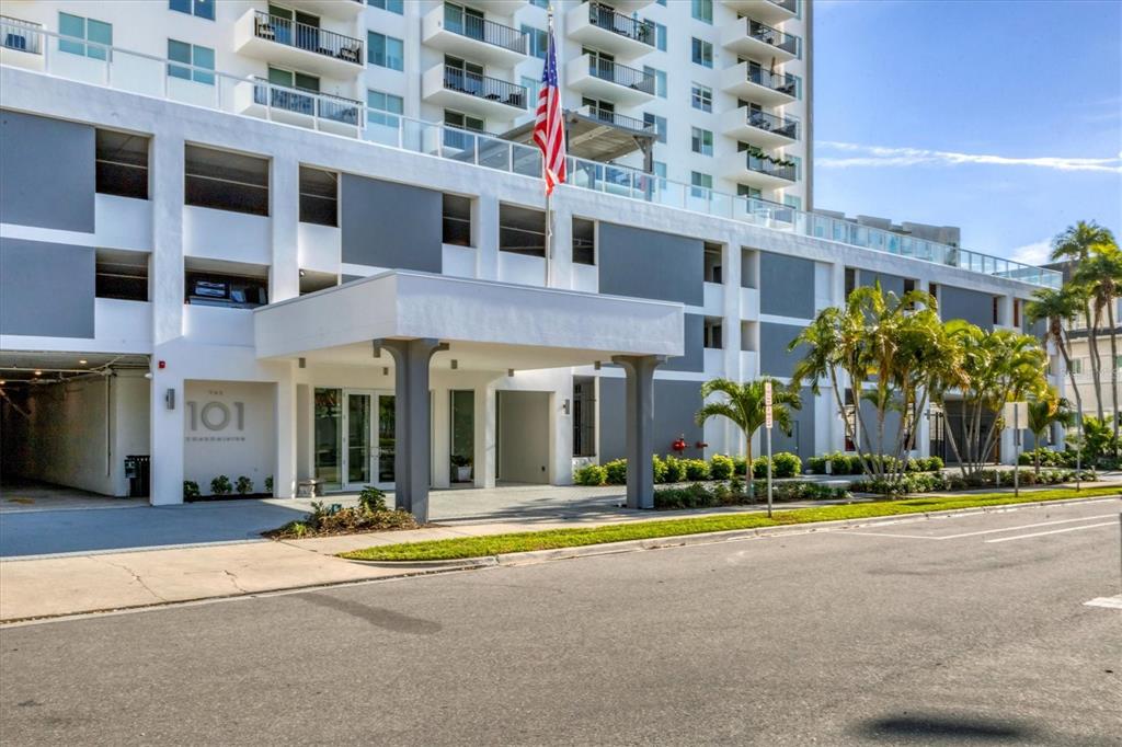 The exterior of a multi-story residential building features a covered entrance and a parking garage — 101 S GULFSTREAM AVENUE UNIT 15E, SARASOTA, FL