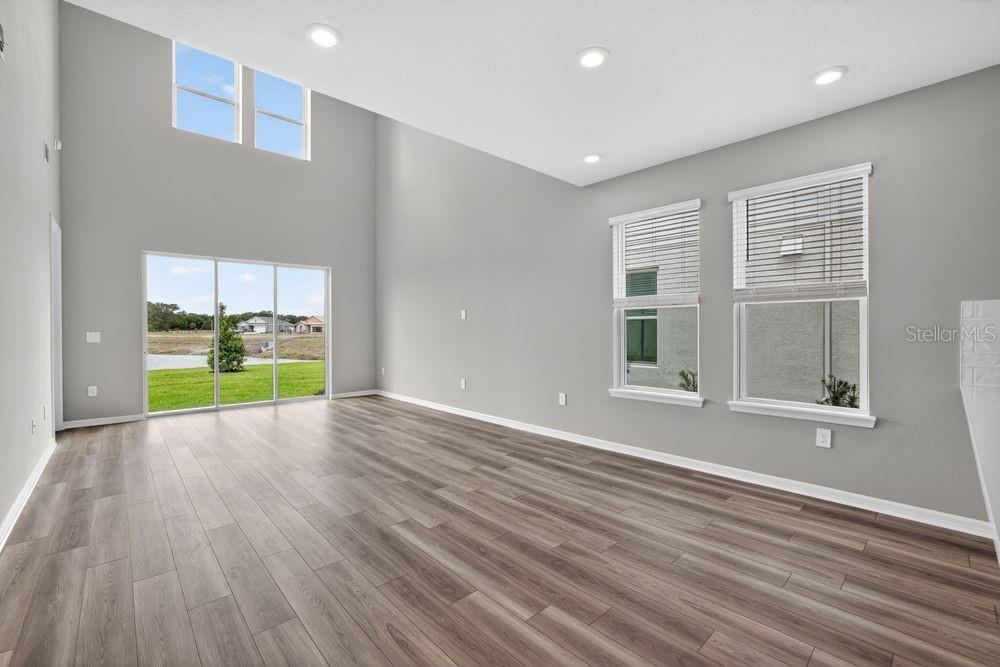 A kitchen with white cabinets, a central island, stainless steel dishwasher, and stairs nearby — 13419 COMMONS AVENUE, PARRISH, FL