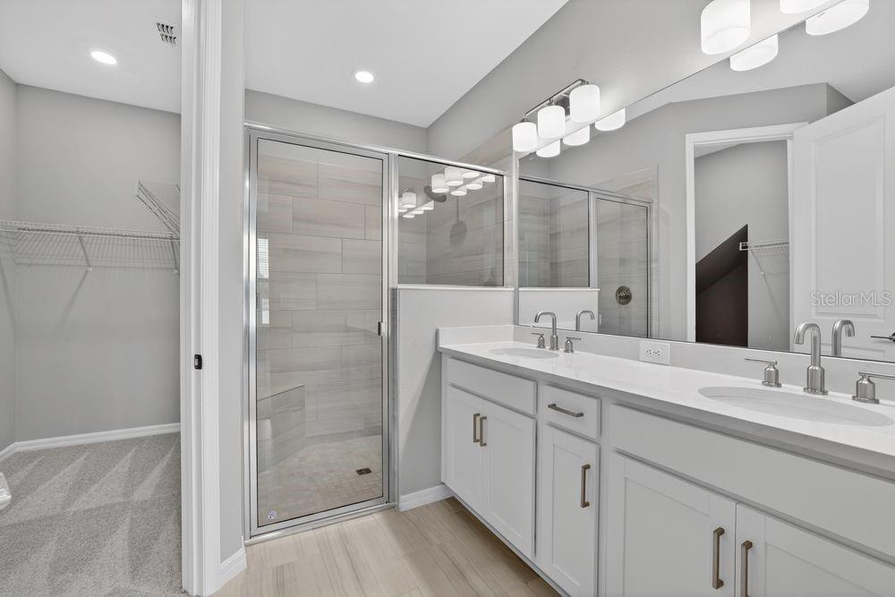 A modern kitchen with white cabinets, stainless steel appliances, and an island overlooking a backyard — 13419 COMMONS AVENUE, PARRISH, FL
