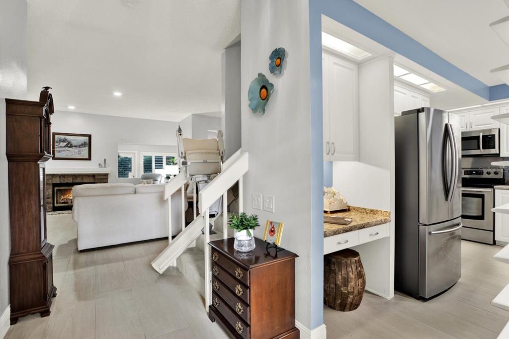 A living room with a fireplace and a kitchen with stainless steel appliances are visible — 3090 LANDMARK BOULEVARD UNIT 1904, PALM HARBOR, FL