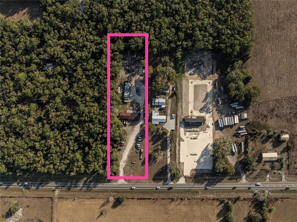 An aerial view shows a rectangular lot outlined in pink containing a house and driveway — 1859 E C 470, SUMTERVILLE, FL