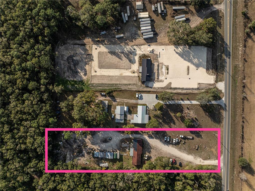 An aerial view shows a rectangular property lot containing a house, outbuildings, and gravel driveway — 1859 E C 470, SUMTERVILLE, FL