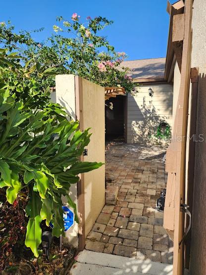 A paved walkway leads through a gate toward the entrance of a house — 3441 BEEKMAN PLACE UNIT 40, SARASOTA, FL