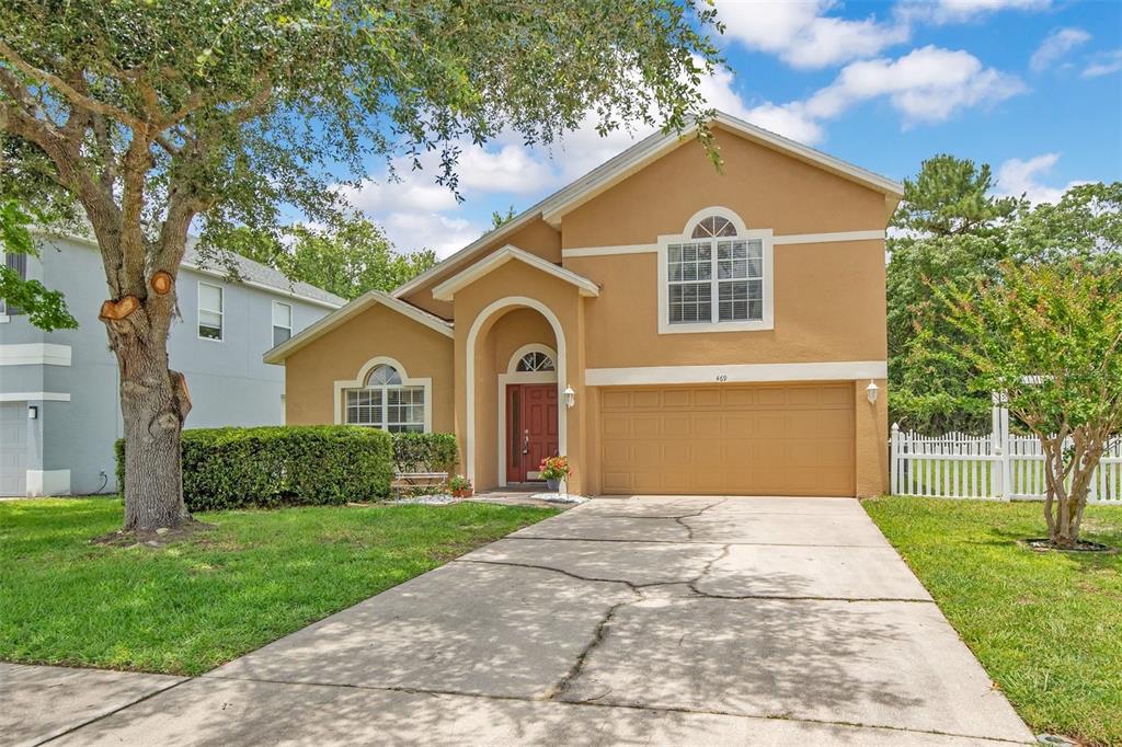 An aerial view of a tan two-story house with a driveway and a white fence — 469 CAREY WAY, ORLANDO, FL