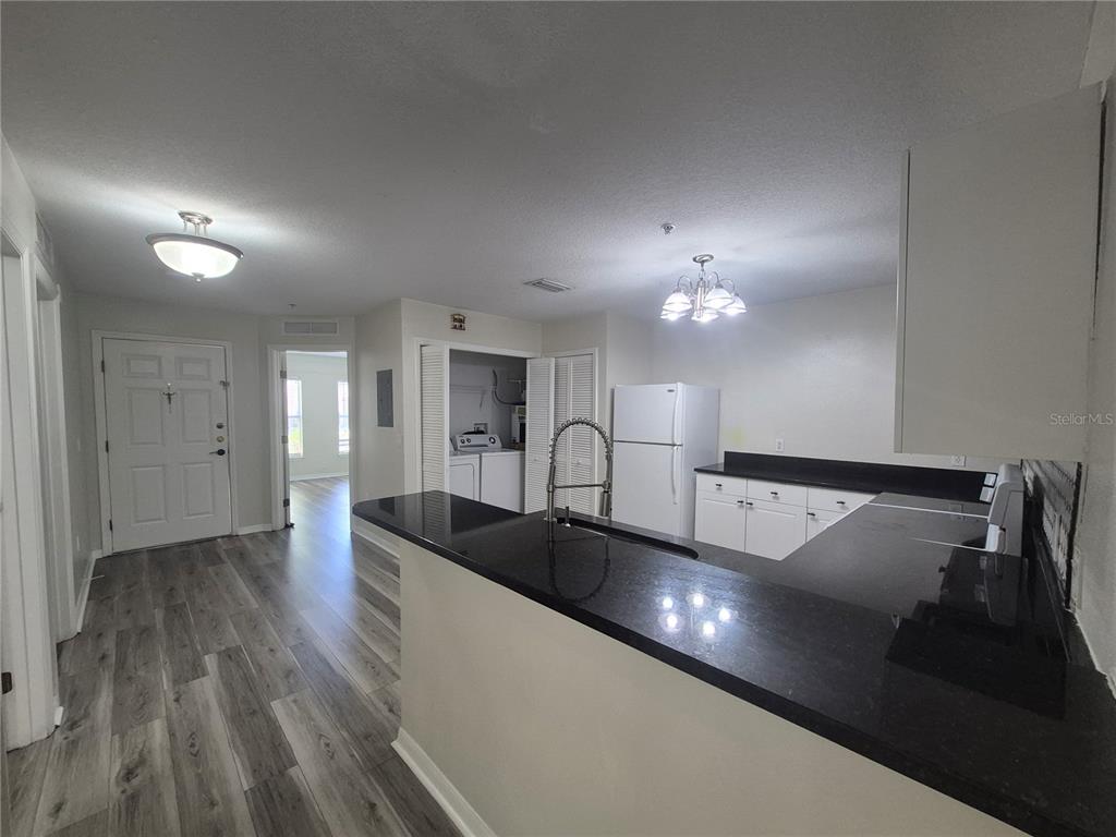 A bathroom features a white toilet next to a glass-enclosed shower with tiled walls — 2720 CLUB CORTILE CIRCLE UNIT A, KISSIMMEE, FL