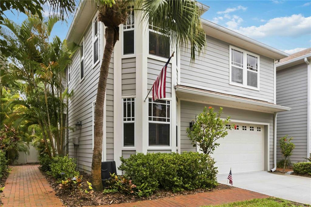 A two-story house with gray siding, a single-car garage, and a palm tree in front — 2869 BAYSHORE TRAILS DRIVE, TAMPA, FL