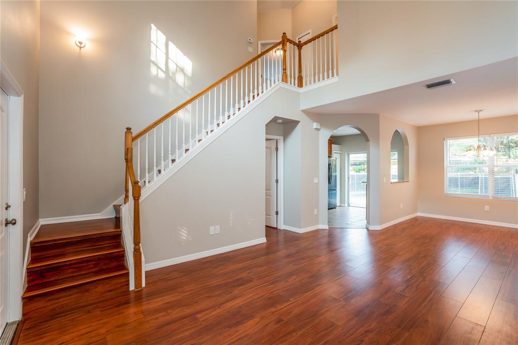 A foyer with wood flooring, a staircase with white railings, and an arched entryway — 1011 LAKE SHORE RANCH DRIVE, SEFFNER, FL