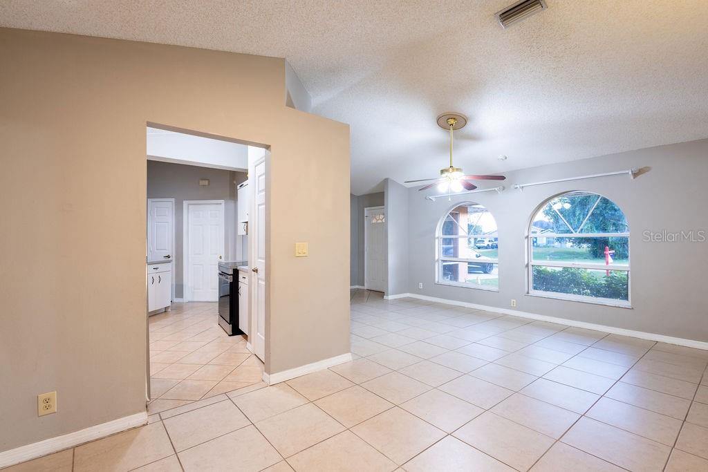 An open living area with tile floors, a ceiling fan, and arched windows — 1570 S BISCAYNE DRIVE, NORTH PORT, FL