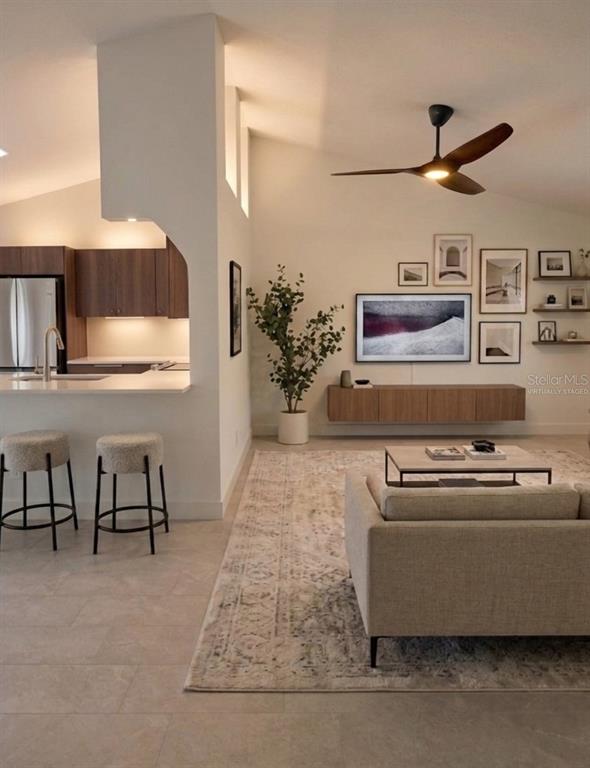 This is a virtually staged living room and kitchen featuring wood cabinetry and neutral furniture — 77 FREEPORT LANE, PALM COAST, FL