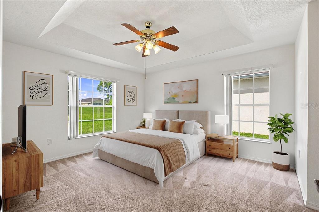 A bedroom features a tray ceiling, a ceiling fan, two windows, and a bed — 347 ROYAL PALM DR, DAVENPORT, FL