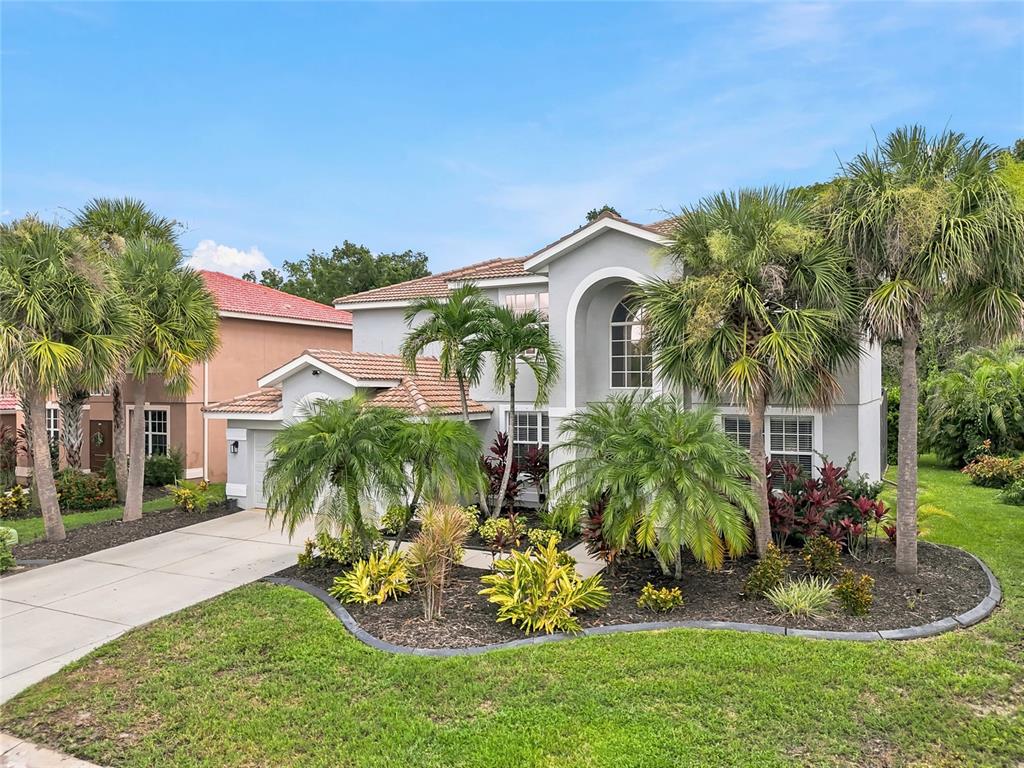 A two-story gray house with a tiled roof and palm trees in the front yard — 227 HERITAGE ISLES WAY, BRADENTON, FL