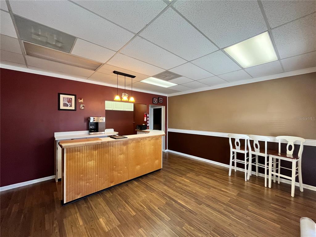 A room with a wooden bar, three white stools, and two-toned walls — 1165 1ST STREET S UNIT 1165, WINTER HAVEN, FL