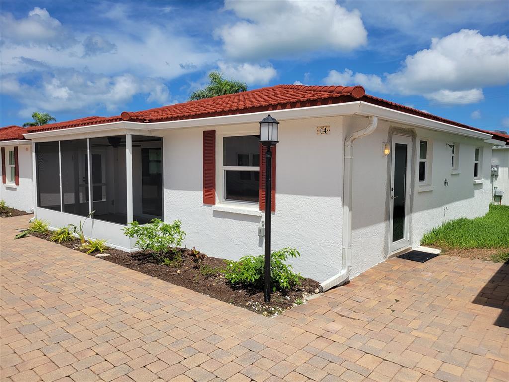 An aerial view shows a residential complex with red-roofed buildings, two swimming pools, and parking — 6154 MIDNIGHT PASS ROAD UNIT VILLA4C, SARASOTA, FL