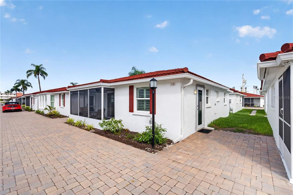 A white single-story villa with a red tile roof and a screened-in patio area — 6154 MIDNIGHT PASS ROAD UNIT VILLA4C, SARASOTA, FL
