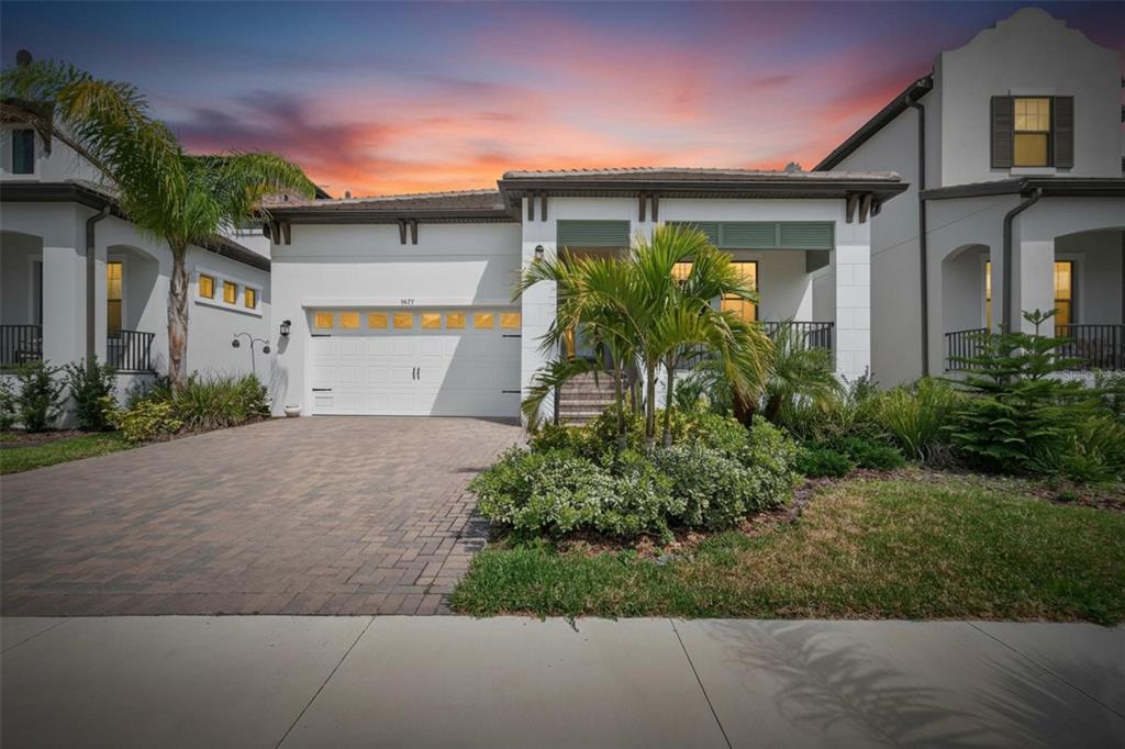 A single-story house with a white exterior, a paved driveway, and a palm tree in front — 1071 SEAGRAPE DRIVE, RUSKIN, FL
