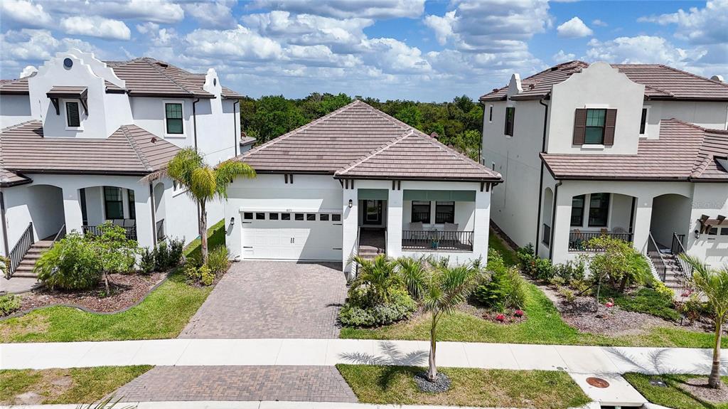 An aerial view shows a single-story house with a tiled roof between two taller homes — 1071 SEAGRAPE DRIVE, RUSKIN, FL