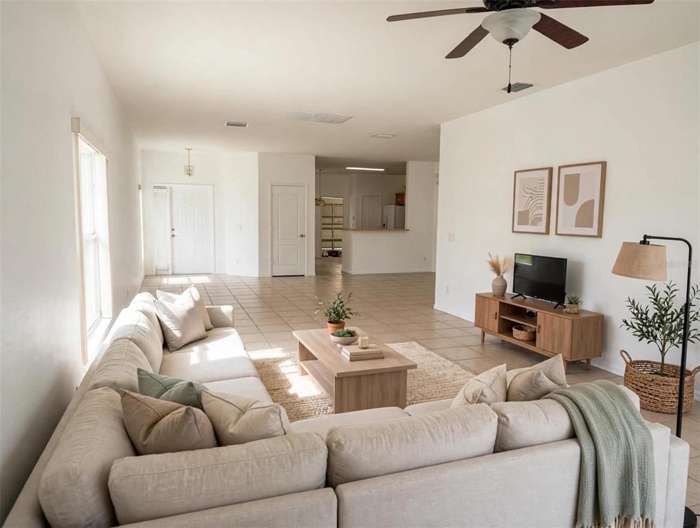 A living room features a large sectional sofa, a coffee table, and a media console — 20008 NOB OAK AVENUE, TAMPA, FL