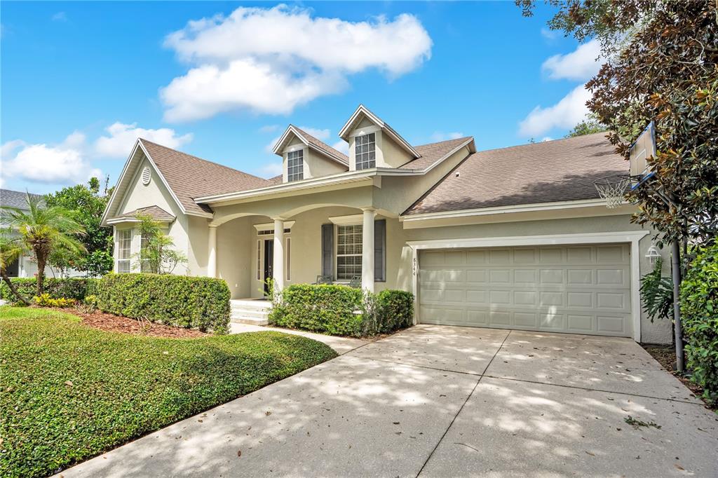 A single-story house with a beige exterior, a two-car garage, and a front porch — 8344 BOWDEN WAY, WINDERMERE, FL