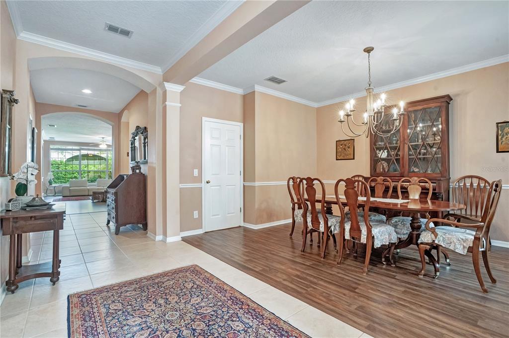 A dining room with wood flooring, a wooden table, chairs, and a china cabinet — 8344 BOWDEN WAY, WINDERMERE, FL