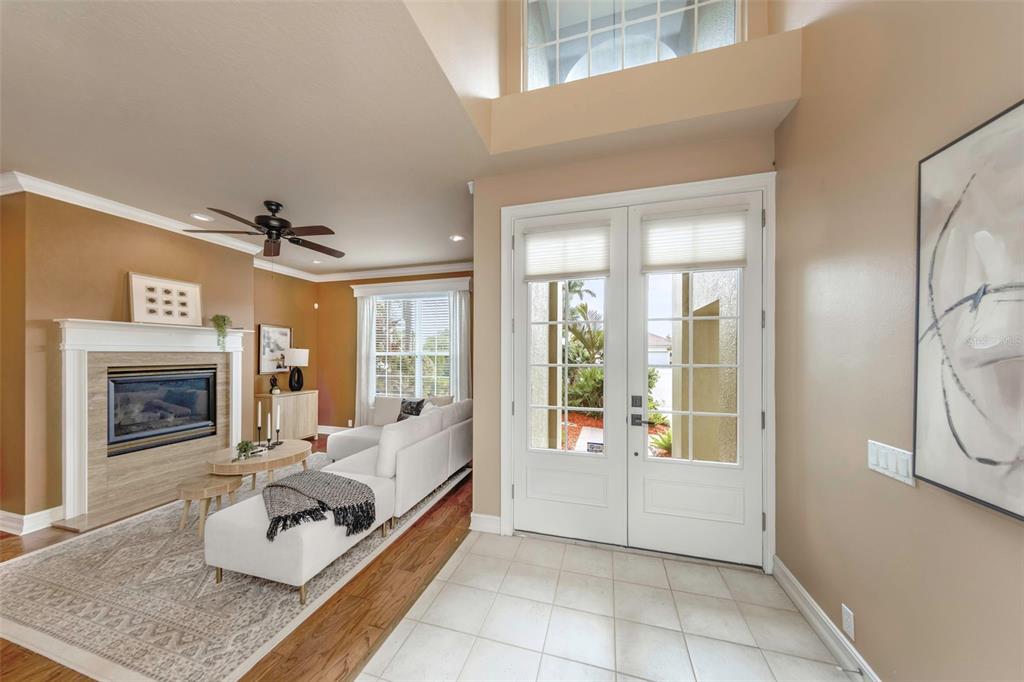 A bright entryway with tile floors leads into a living room featuring a fireplace — 313 10TH AVENUE E, PALMETTO, FL