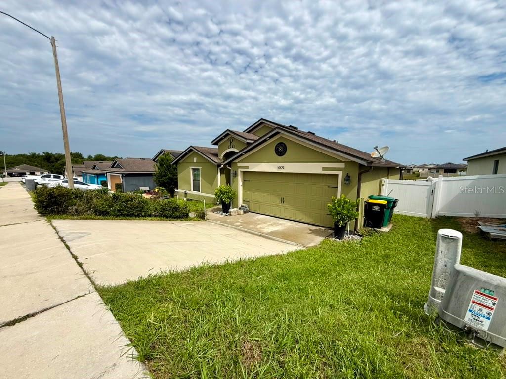 A single-story house with a green exterior, a two-car garage, and a concrete driveway — 1609 STEELY DRIVE, DUNDEE, FL