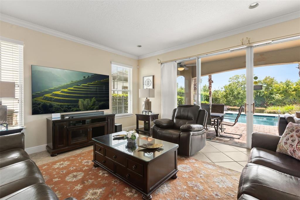 A two-story house features a backyard pool, a stone fire pit, and palm trees — 796 DESERT MOUNTAIN COURT, KISSIMMEE, FL