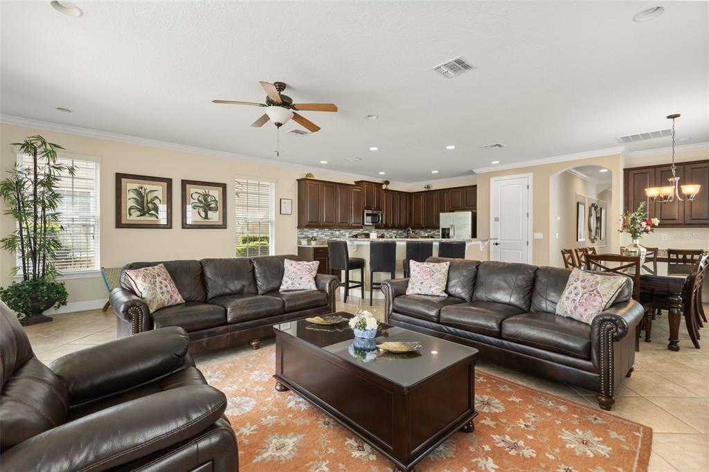 A kitchen features dark wood cabinets, granite countertops, a breakfast bar with four chairs, and tile flooring — 796 DESERT MOUNTAIN COURT, KISSIMMEE, FL