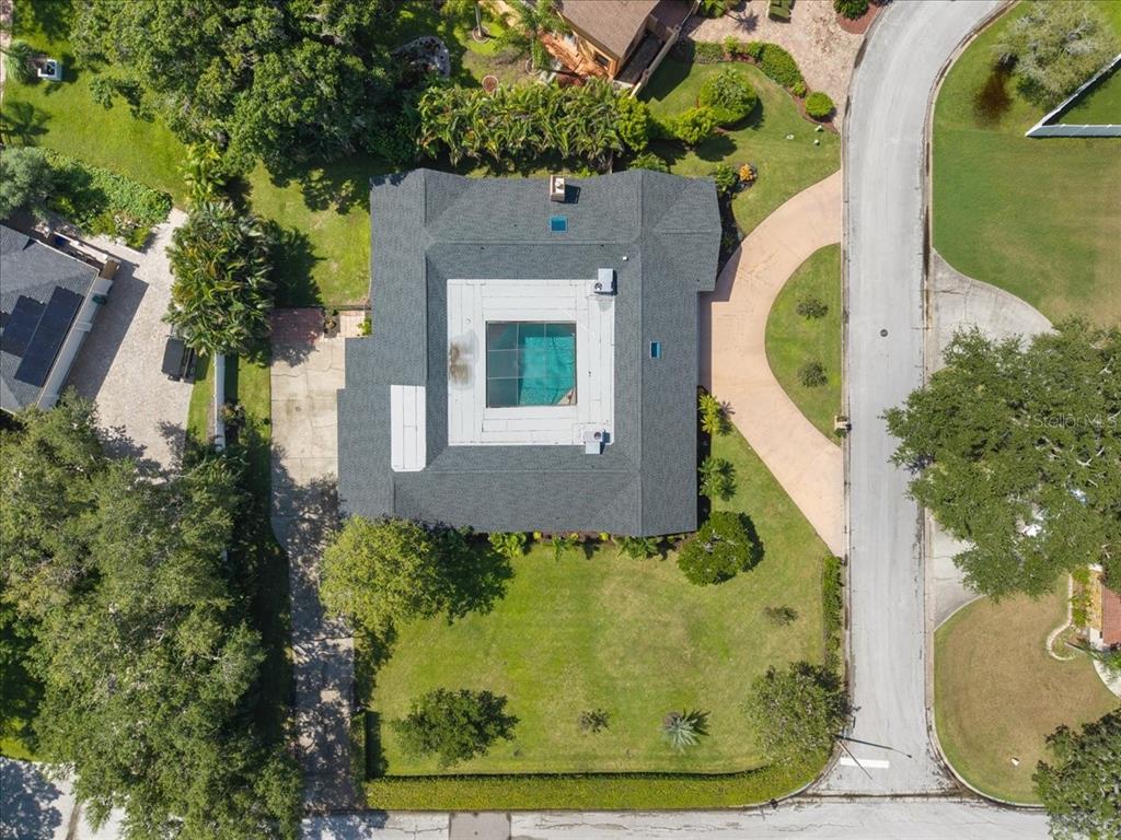 An aerial view shows a house with a central courtyard pool and a shingled roof — 1701 ALLENS CREEK DRIVE, CLEARWATER, FL