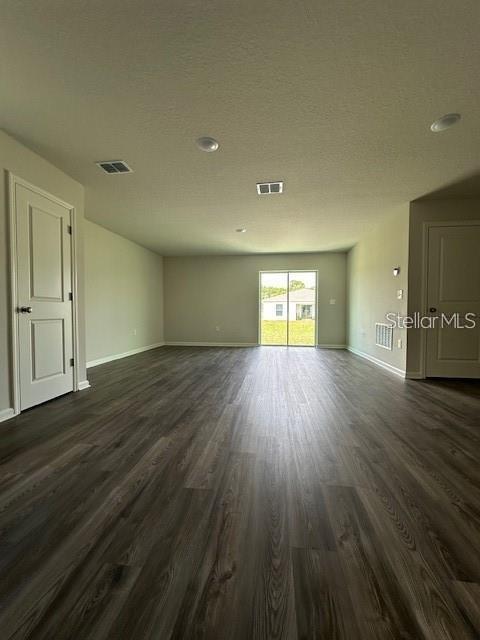 An empty room features wood-look flooring, recessed lighting, and a sliding glass door to the outside — 2432 NW 22ND COURT, OCALA, FL