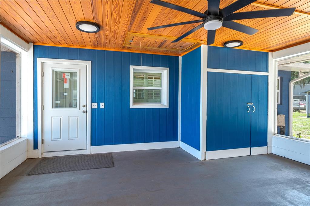 A covered porch features blue vertical siding, a wood-paneled ceiling, and a ceiling fan — 10742 W BEACH PARKWAY, LAKE WALES, FL