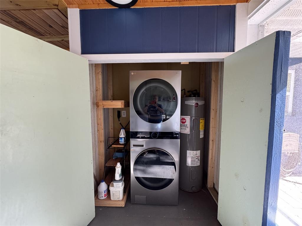 A laundry closet contains a stacked washer and dryer unit next to a water heater — 10742 W BEACH PARKWAY, LAKE WALES, FL