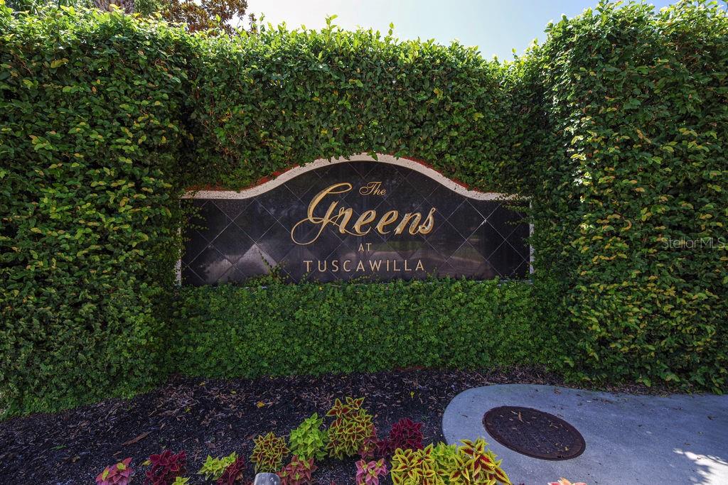A grassy backyard features a black metal fence, lush landscaping, and a view of water — 1541 CORKERY COURT UNIT 1541, WINTER SPRINGS, FL