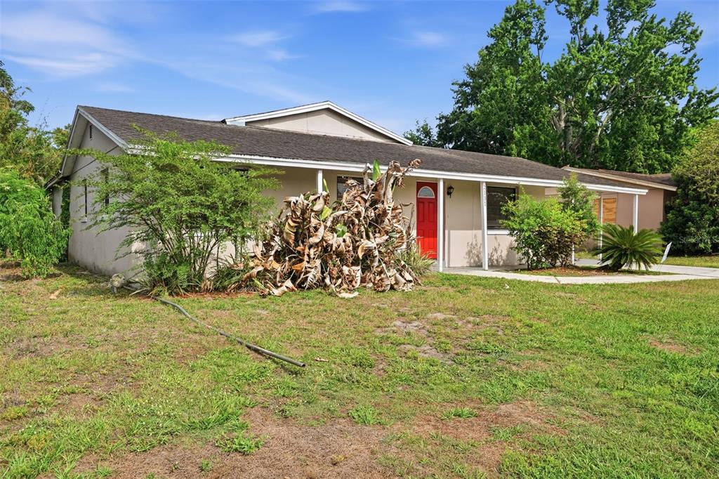 A single-story house with a red front door, a covered porch, and a large yard — 2131 MESSINA AVENUE, ORLANDO, FL