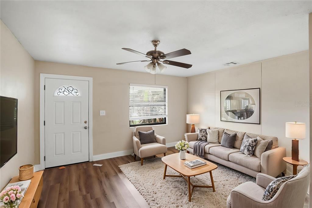 A living room features a beige sofa, two armchairs, a coffee table, and wood-look flooring — 2131 MESSINA AVENUE, ORLANDO, FL