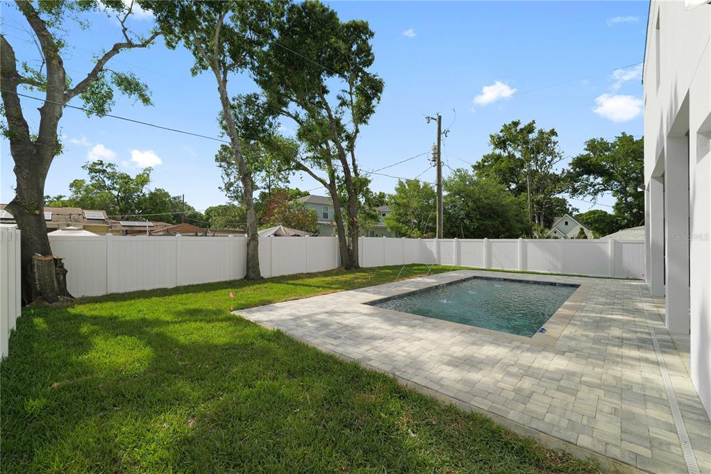 A covered patio features a swimming pool, outdoor dining area, and dark wood-paneled ceiling — 2308 1/2 N ELCOE DRIVE, TAMPA, FL