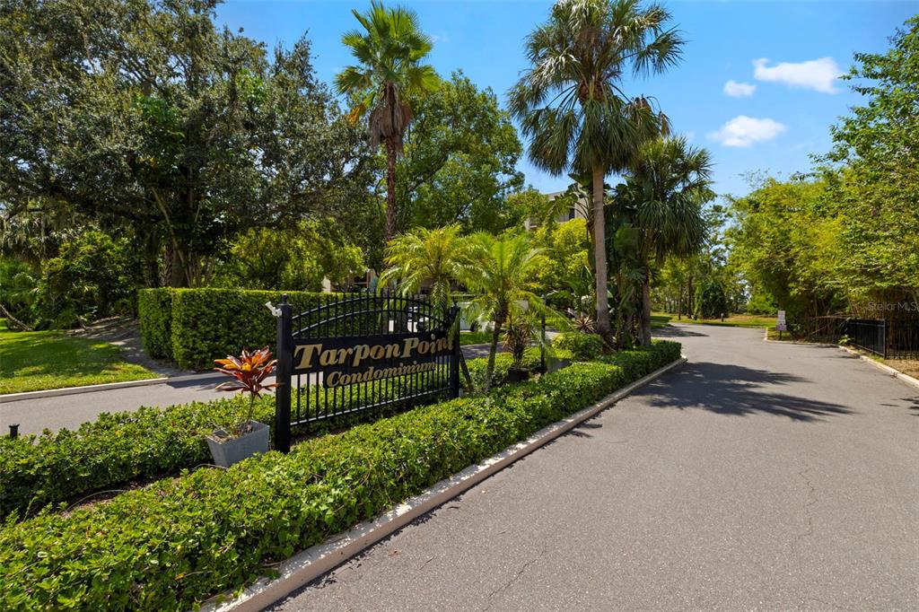 A kitchen features white cabinets, stainless steel appliances, a black refrigerator, and a tiled backsplash — 402 TARPON POINT, TARPON SPRINGS, FL
