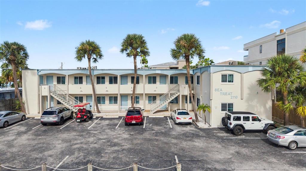 A two-story motel building with a parking lot and palm trees in front — 2110 GULF BOULEVARD UNIT 6, INDIAN ROCKS BEACH, FL