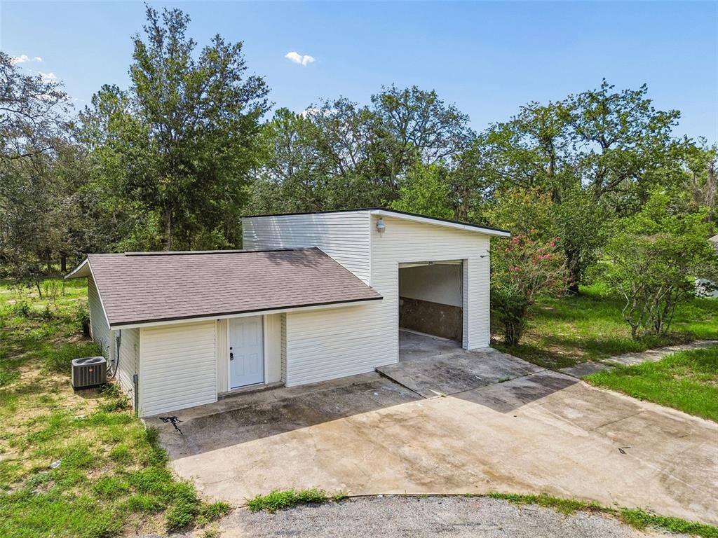 A white house with a concrete walkway, exterior lighting, and a covered patio beside a pool — 17503 GALVESTON STREET, SPRING HILL, FL
