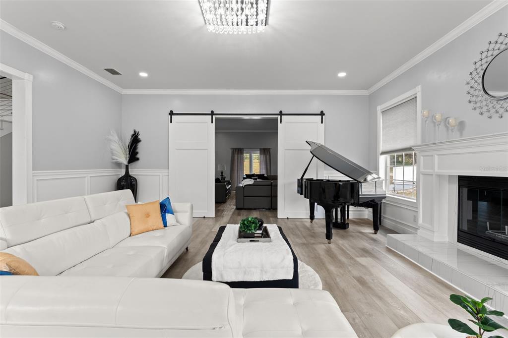 A living room features a white sectional sofa, a grand piano, and a fireplace — 14485 SWITCH BACK ROAD, SPRING HILL, FL