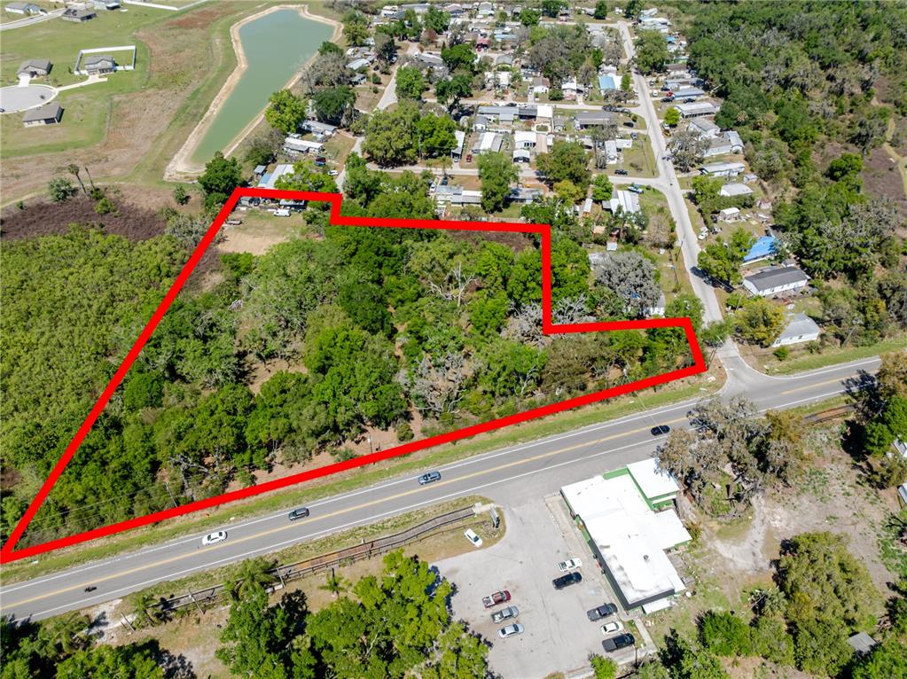 An aerial view shows a wooded lot outlined in red next to a paved road — 1120 NORTHWOOD DRIVE, SEFFNER, FL