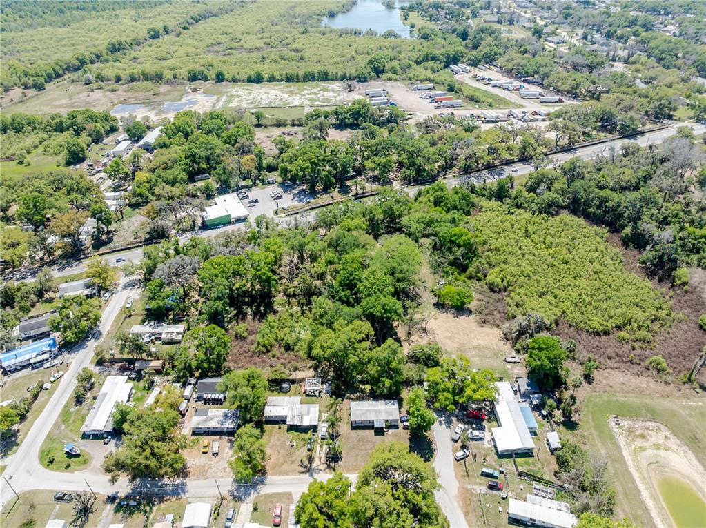 An aerial view shows a residential area with mobile homes, trees, and a nearby highway — 1120 NORTHWOOD DRIVE, SEFFNER, FL